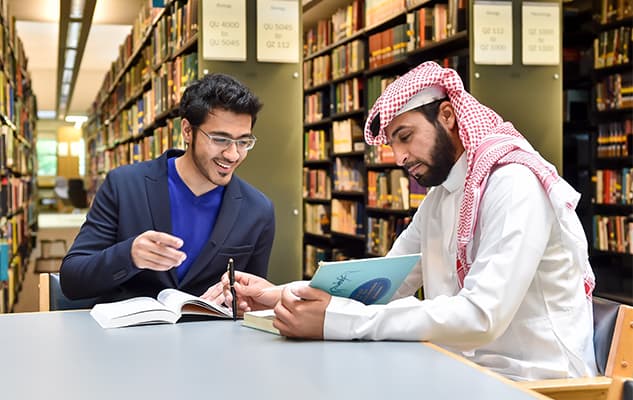 Students studying in modern Saudi university library
